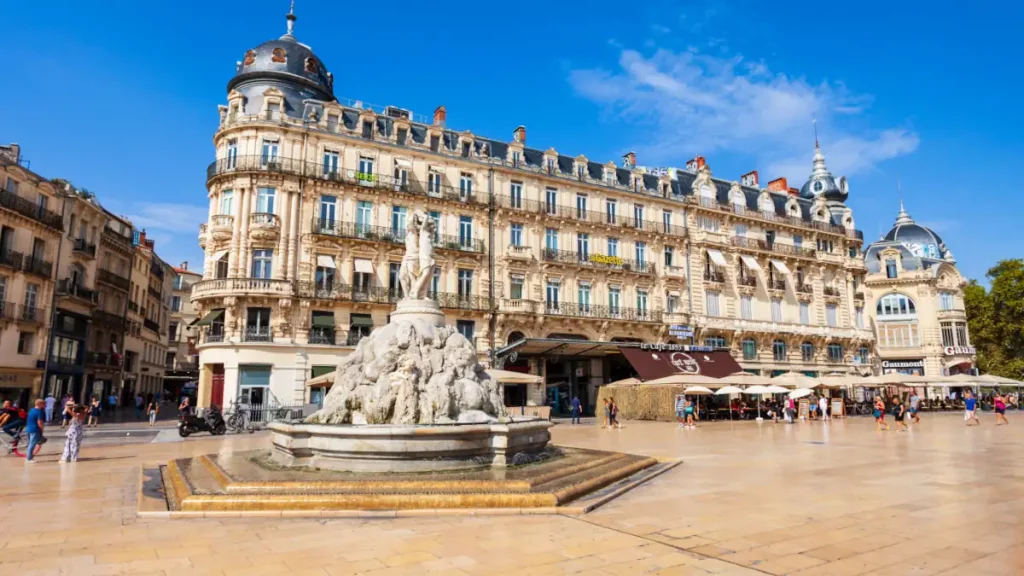 Place de la Comédie à Montpellier avec fontaine et immeubles haussmanniens, un lieu central pour les agences immobilières locales.